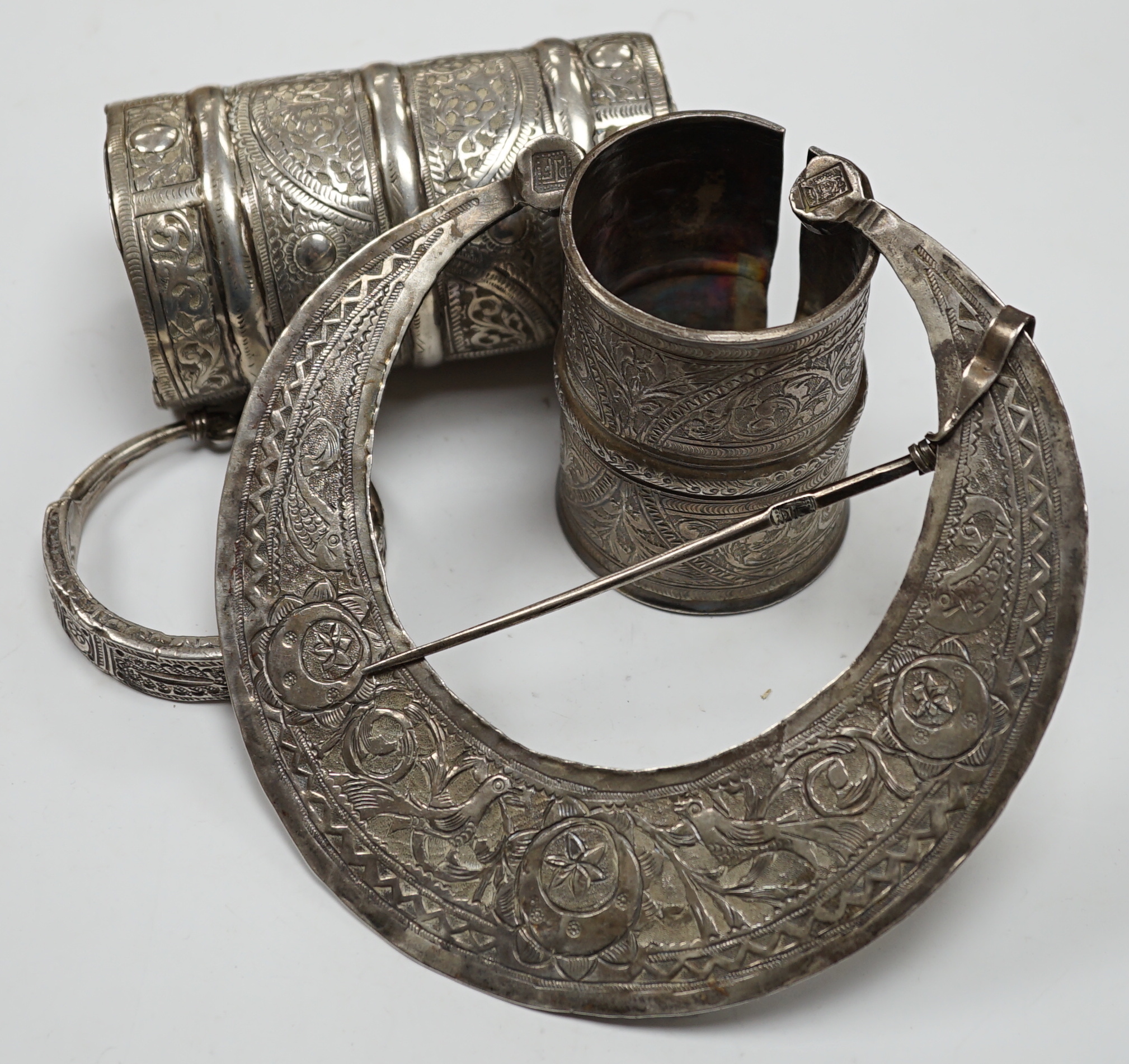 A collection of eight North African Berber white metal jewellery, etc, including bangles, cuffs and hair ornament.